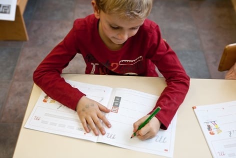 Linkshandige kinderen zien steeds een voorbeeld bij het schrijven van een letter.
